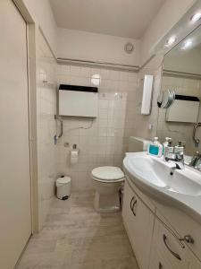 un bagno bianco con un water e un lavandino di Ferienwohnung Fördeblick 7605 in Marina Wendtorf a Wendtorf Altre 10 foto