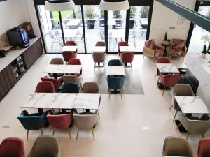 une salle de classe avec des tables et des chaises dans un bâtiment dans l'établissement Arrow Hôtel, à Hégenheim