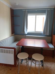 a dining room with two tables and two stools at Camping Relax Sol in Torredembarra