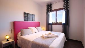 een slaapkamer met een roze bed en handdoeken bij Sa Pobla - 1583 Mallorca in Sa Pobla