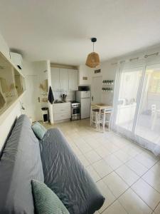 a living room with a couch and a kitchen at Appart CLIM , WIFI, PLAGE 200 mètres in Argelès-sur-Mer