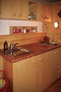una cocina con fregadero y armarios de madera en Casetta sul Lago di Misurina, en Misurina