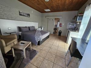 ein Schlafzimmer mit einem Bett und ein Wohnzimmer in der Unterkunft ZUCH Accommodation at Pafuri Self Catering - Guest Suite in Polokwane