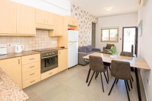 eine Küche und ein Esszimmer mit einem Tisch und Stühlen in der Unterkunft Bowker Apartment in Protaras