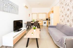 ein Wohnzimmer mit einem Sofa und einem Tisch in der Unterkunft Bowker Apartment in Protaras