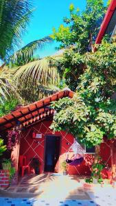 a red building with a black door and trees at Sakleshpur home stay in Sakleshpur