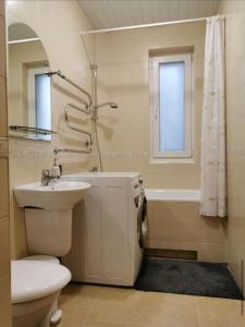 La salle de bains est pourvue de toilettes, d'un lavabo et d'une baignoire. dans l'établissement Vasario 16-osios 27 Kambarių nuoma, à Palanga