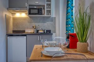 eine Küche mit einem Tisch und Weingläsern darauf in der Unterkunft Le Charreton 2 - Ile Verte - CHU de Grenoble in Grenoble