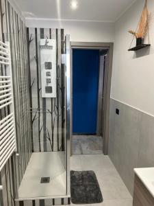a bathroom with a shower with a blue wall at Pura Vida Apartment in Catania +17 photos