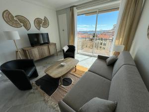 uma sala de estar com um sofá e uma grande janela em Esperance em Cannes