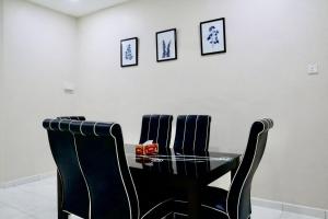 een zwarte eettafel met vier zwarte stoelen bij MH Homestay No3 for 6ppl at Alor Setar in Alor Setar