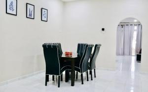 een eetkamer met een zwarte tafel en stoelen bij MH Homestay No3 for 6ppl at Alor Setar in Alor Setar