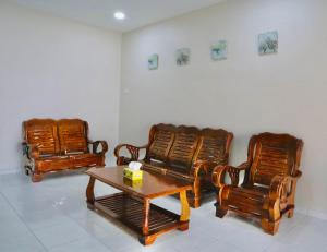 drie houten stoelen en een tafel in een kamer bij MH Homestay No3 for 6ppl at Alor Setar in Alor Setar