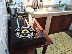 a stove top oven in a kitchen next to a sink at Kabale town flat (sitting and bedroom) in Kabale