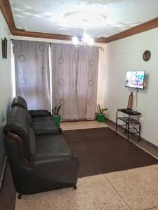 a living room with a leather couch and a table at Kabale town flat (sitting and bedroom) in Kabale