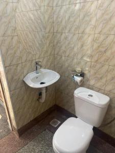 a bathroom with a white toilet and a sink at Kabale town flat (sitting and bedroom) in Kabale
