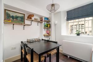 a dining room with a black table and chairs at Riverside 1 Bed Basement Flat near Hampton Court Palace in East Molesey +31 photos