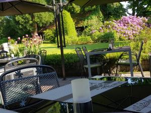 un patio al aire libre con mesas, sillas y flores en Landgasthof Hotel Hirsch en Marktlustenau