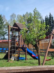 un parque infantil con un tobogán y un árbol en Ferienhaus Hochwald, 