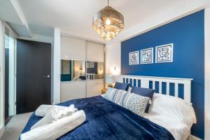 a bedroom with a blue accent wall and a bed at Riverside 1 Bed Basement Flat near Hampton Court Palace in East Molesey