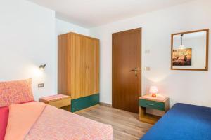 1 dormitorio con 1 cama y armario de madera en Agriturismo El Cirum Boe, en Livinallongo del Col di Lana