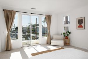 um quarto com paredes brancas e uma grande janela em Modern beach home with rooftop - Ocean View! em Oceanside