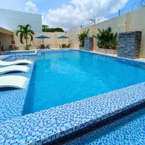 una gran piscina con azulejos azules en un hotel en Cabañas covemar, en Coveñas