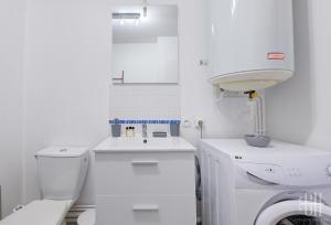 a white bathroom with a toilet and a sink at Le Florey / Hôpital Trousseau in Chambray-lès-Tours