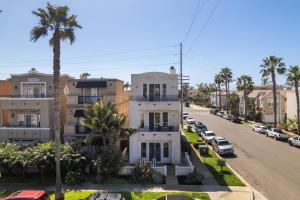 an apartment building on a street with palm trees at Modern beach home with rooftop - Ocean View! in Oceanside