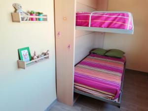 a bunk bed in a small room with purple sheets at Montaña & Mar in Miami Platja