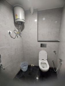 a bathroom with a toilet and a water tank at Hotel Black Eye in New Delhi