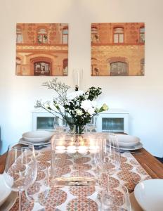 einen Esstisch mit Gläsern und eine Vase Blumen in der Unterkunft Brody Art Boutique Apartment in Budapest