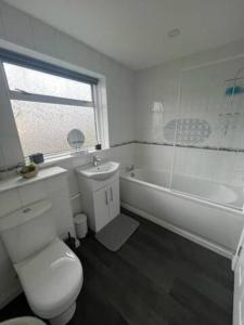a bathroom with a toilet and a sink and a tub at 3 Bedroom House - Ideal for Contractors - Sleeps 6 in Runcorn