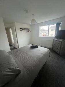 a bedroom with a large bed and a window at 3 Bedroom House - Ideal for Contractors - Sleeps 6 in Runcorn