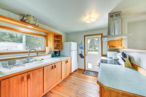 a kitchen with a sink and a refrigerator at Clark Fork Vacation Home with Wood Stove Near Lake! in Clark Fork