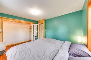 a bedroom with a bed and a blue wall at Clark Fork Vacation Home with Wood Stove Near Lake! in Clark Fork