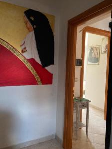 a woman is sitting on a bed in a room at S'imbustHouse in Oristano