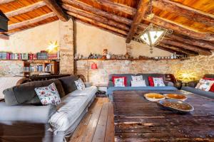 sala de estar con sofás y mesa de madera en Can Miqueló - casa rural 16 hòstes, en Prat de Comte