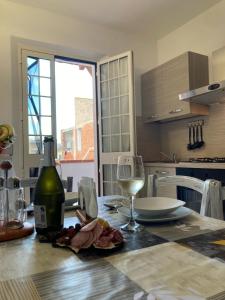 a kitchen with a table with a bottle of wine and glasses at S'imbustHouse in Oristano