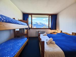 a bedroom with two bunk beds and a window at Hostdomus - Sansicario R8 in San Sicario