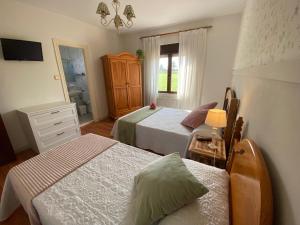 a bedroom with two beds and a dresser at Hospedaje Oreña in Oreña