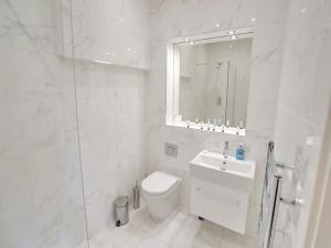 a white bathroom with a toilet and a sink at Pass the Keys Large Central Flat Walk To City Centre In 5 Mins in Manchester