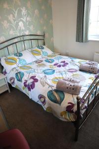 una camera da letto con un letto con copriletto floreale di In Our Liverpool Home Sleeps 5 in 2 Double & 1 Single Bedrooms a Liverpool