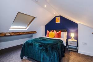 1 dormitorio con 1 cama con almohadas de color naranja en Fantastic Five Bedroom House By PureStay Short Lets & Serviced Accommodation South Yorkshire With Parking, en Bentley