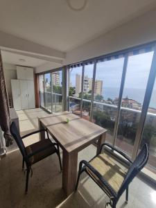 een tafel en stoelen in een kamer met een groot raam bij Appartement Benidorm sea view in Benidorm