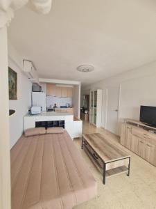 een woonkamer met een tafel en een keuken bij Appartement Benidorm sea view in Benidorm