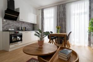 ein Wohnzimmer mit einem Tisch und einer Küche in der Unterkunft HM • Cosy 1BR Near Westbahnhof in Wien