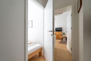 Schlafzimmer mit einer Tür, die in ein Zimmer mit einem Bett führt in der Unterkunft HM • Cosy 1BR Near Westbahnhof in Wien