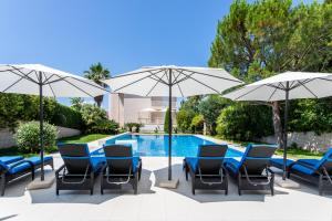 een groep stoelen en parasols naast een zwembad bij Apartments Keti in Splitska
