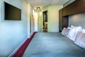 Cette chambre comprend un lit et une télévision à écran plat. dans l'établissement Hotel Atlantis Amsterdam, à Amsterdam